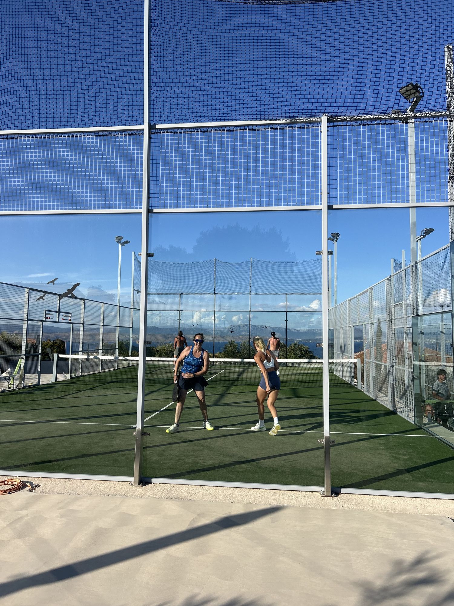 Two players laughing, seen through the glass wall